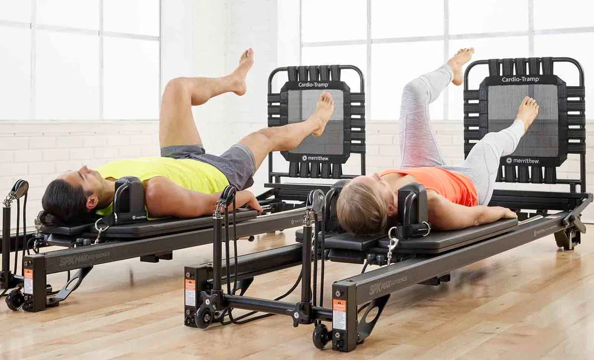 pilates-reformer-rebound-pilates10 Alumnes realitzant estiraments sobre màquines de Pilates Reformer