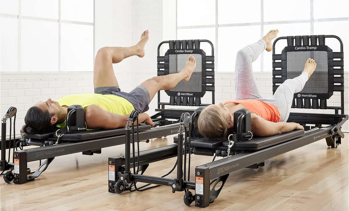 Alumnas realizando estiramientos sobre máquinas de Pilates Reformer