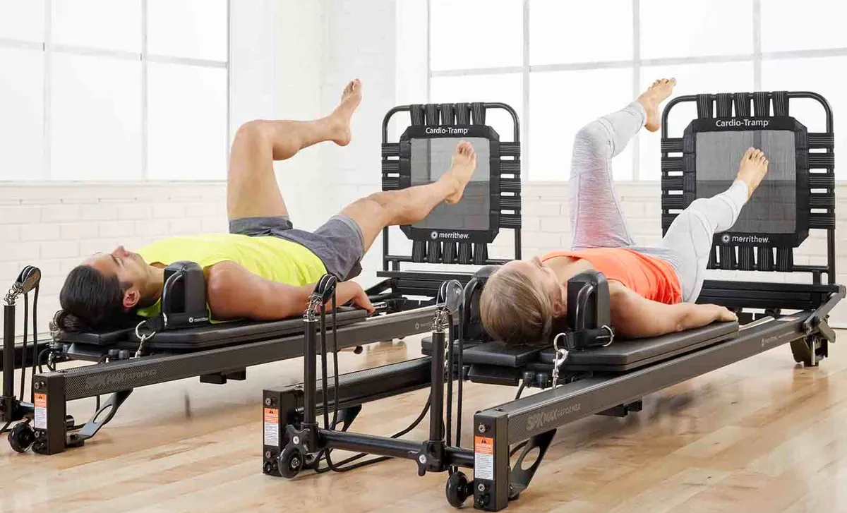 pilates-reformer-rebound-pilates10 Dos personas realizando ejercicios de Pilates Reformer Rebound con Cardio-Tramp